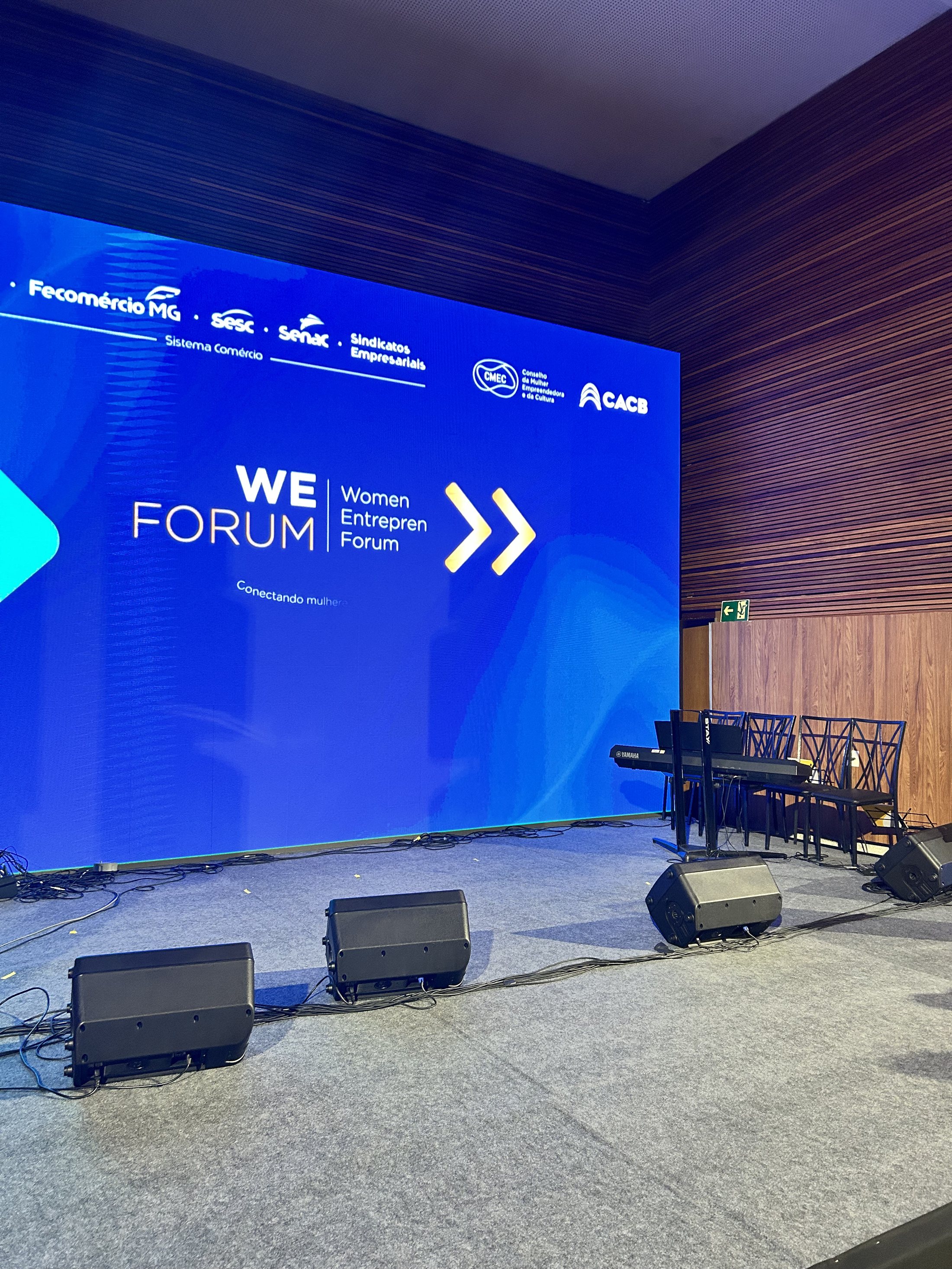 Palco do WE Forum com painel azul e instrumentos preparados